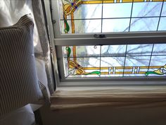 a window with stained glass and pillows on it