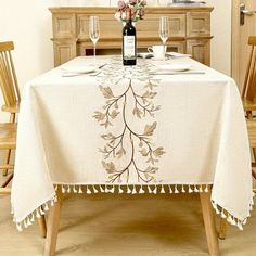 a dining room table with a bottle of wine and two glasses on top of it