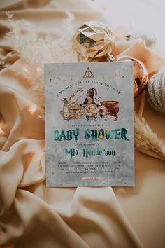 a baby shower sign sitting on top of a bed next to toys and other items