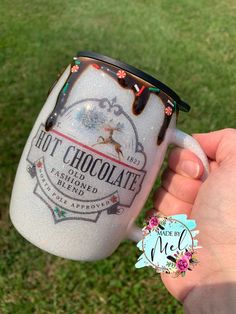 a hand holding a coffee mug with chocolate on it