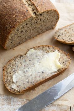 a loaf of bread sitting on top of a cutting board next to a butter knife