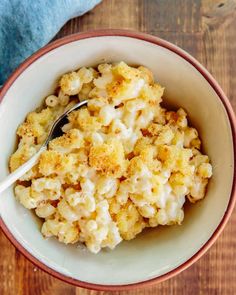 a bowl filled with macaroni and cheese on top of a wooden table