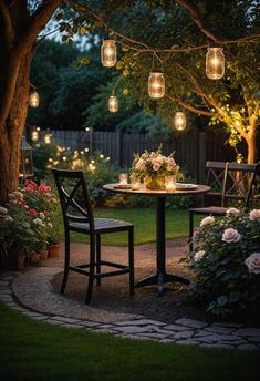 a table and chairs in the middle of a garden with lights hanging from it's branches