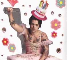 a man sitting on top of a chair wearing a birthday hat and holding a cake