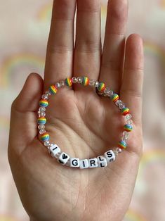 a hand holding a beaded bracelet that says girls