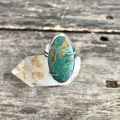 "This handmade sterling silver ring features a natural, high grade Turquoise Mountain stone in a smooth bezel with prong details, along a wide, comfortable band. The stone is a beautiful, green color, mined here in the USA. The setting is entirely handmade, crafted of fine silver (.999) and sterling silver (.925) and has been oxidized to highlight the fine details and then polished to a high shine. Face of ring measures 1 1/4\"tall x 5/8\" wide. Ring is a US size 7.5 and cannot be resized. Pleas Untreated Chrysocolla Turquoise Ring In Silver, Unique Turquoise Oval Cabochon Ring With Large Stone, Unique Large Stone Oval Cabochon Turquoise Ring, Artisan Turquoise Chrysoprase Rings, Turquoise Oval Cabochon Ring With Large Stone, Oval Turquoise Chrysoprase Ring, Turquoise Chrysoprase Ring, Adjustable Chrysocolla Turquoise Ring, Silver Turquoise Ring With Cabochon Chrysoprase