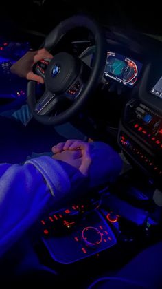 a person sitting in a car with their hands on the steering wheel