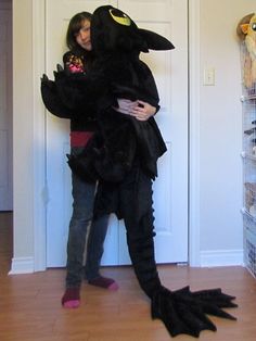 a person in a costume standing next to a door with a stuffed animal on it's back