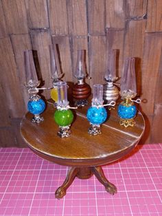 a wooden table topped with glass vases and candles