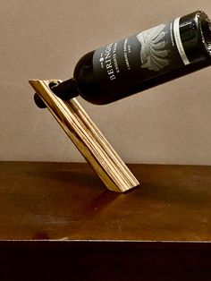 a wine bottle that is sitting on top of a wooden stand with a cork in it