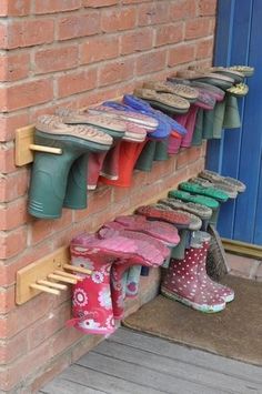 there are many pairs of shoes hanging up on the brick wall next to each other