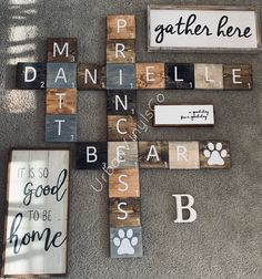 a cross made out of wooden blocks with words on it and paw prints around the edges