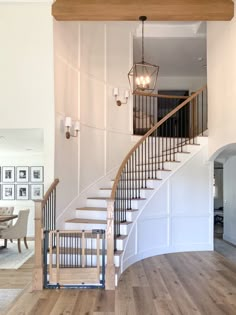 a staircase leading up to a living room and dining room in a house with white walls