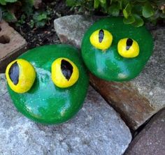 two green rocks with yellow eyes on them