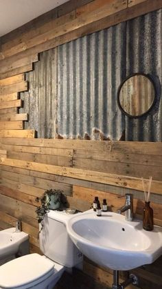 a bathroom with two toilets and a sink made out of wooden planks, along with a corrugated wall