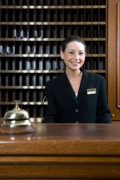 a woman sitting at the front desk of a hotel