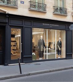 a store front with mannequins in the window and on the street corner