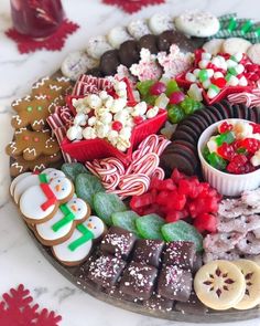 a platter filled with lots of different types of cookies and candies on top of a table