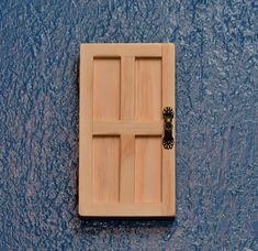 a wooden door on the side of a blue wall with an iron handle and knob