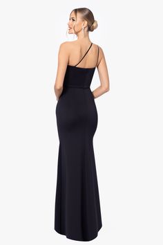 a woman in a long black dress with one shoulder and open back, looking to the side