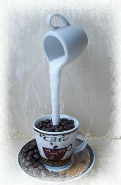 a cup filled with coffee beans and milk being poured into it