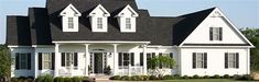 a large white house with black roof and windows