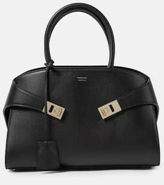 Hug Small leather tote bag in black - Ferragamo | Mytheresa High-end Office Shoulder Bag With Silver-tone Hardware, High-end Office Satchel With Silver-tone Hardware, Leather Satchel With Branded Hardware For Office, Leather Shoulder Bag With Branded Hardware For Office, Business Satchel With Silver-tone Hardware And Calf Leather, Modern Leather Satchel With Branded Hardware, Business Calf Leather Satchel With Silver-tone Hardware, Leather Satchel With Silver-tone Hardware For Office, Office Shoulder Bag With Metal Hardware In Calf Leather