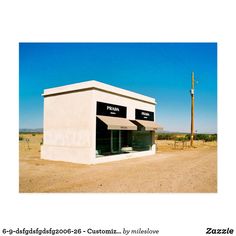 a small white building sitting on the side of a dirt road