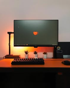 a computer monitor sitting on top of a wooden desk next to a keyboard and mouse