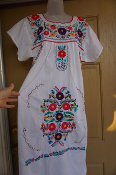 A fun summery Mexican fiesta dress with floral embroidery. No tags found. Please refer to measurements below for sizing. In good vintage condition and ready to wear but is slightly sheer and may need a slip - see last photo. MEASUREMENTS (taken with the garment laid flat) Underarm to underarm- 21 inches Waist- 25 inches across front Length: 46 inches I believe this would fit a modern day large comfortably. Floral Embroidered Dress For Fiesta Festivals, Folk Style Floral Print Embroidered Dress For Festival, Folk Style Embroidered Floral Dress For Festivals, Floral Embroidered Beach Dress For Fiesta, Floral Embroidered Dress For Beach Fiesta, Folk Style Floral Embroidered Dress For Cinco De Mayo, Floral Embroidery Dresses For Cinco De Mayo Vacation, Floral Embroidered Dress For Cinco De Mayo Festival, Floral Embroidered Dress For Cinco De Mayo