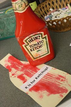 a bottle of ketchup sitting on top of a table next to some paper