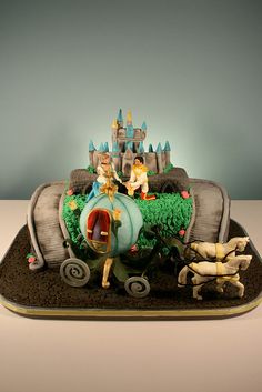 there is a cake that looks like a horse drawn carriage with people riding on it