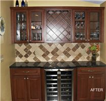 a wine cooler in the corner of a kitchen with wooden cabinets and tile backsplash