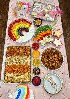 a table filled with lots of food on top of a pink table cloth covered in confetti