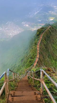 stairs leading up to the top of a mountain with lush green hills in the background