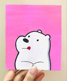 a hand holding up a piece of paper with a drawing of a polar bear on it