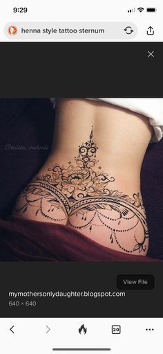 the back of a woman's stomach with an intricate tattoo design on her side