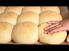 a person is reaching for some bread rolls