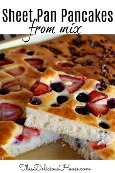 a close up of a cake with strawberries and blueberries on it's crust