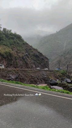 the road is wet from rain, and there are mountains in the background