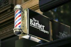 the barber company sign is attached to a building