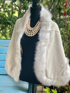 Introducing our luxurious White Winter Cape, the perfect addition to elevate your winter and formal wear. Crafted with trimmed faux fur, this cape exudes elegance and sophistication. The inner fabric is made with a soft and matching satin layer, giving it a polished and refined look. Designed to suit a variety of occasions, this cape is perfect for brides, bridal parties, shows, casual outings, school, office, dates, and parties, making it a versatile and essential piece for your wardrobe. It is suitable for the winter, early spring, and cold autumn seasons. To maintain its exquisite quality, we recommend dry cleaning only. However, you may also hand wash it in cold water and hang to dry. Please note, machine washing is not recommended. Measuring at a free size, with a width of 23.6''/60cm Elegant Winter Capelet, Elegant Fall Cape For Party, Elegant Cape For Fall Party, Elegant Fall Party Cape, Elegant Cape Fur Coat With Faux Fur Trim, Elegant Cape-style Fur Coat With Faux Fur Lining, Elegant Fur Cape Coat With Faux Fur Trim, Elegant Fur Coat With Faux Fur Trim Cape, Elegant Evening Capelet For Winter