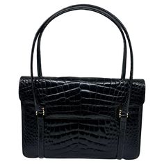 This elegant vintage 1950s black crocodile top-handle bag exudes timeless sophistication and classic style. Crafted from genuine crocodile leather, the bag features a sleek and structured silhouette, typical of mid-century fashion. The glossy black finish highlights the distinctive texture of the crocodile pattern, adding depth and luxury to its appearance. The bag is designed with a sturdy, curved top handle that provides a comfortable grip while enhancing its refined aesthetic. Its flap closur Jimmy Choo Clutch, Crocodile Handbags, Mid Century Fashion, Louis Vuitton Limited Edition, Refined Aesthetic, Vintage Shoulder Bag, Crocodile Pattern, Crocodile Leather, Black Leather Bags