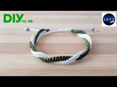 a white and green string bracelet on top of a wooden table with the words diy no