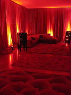 a living room with red lighting and couches