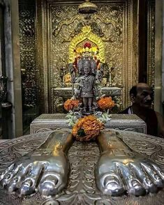 an ornately decorated table with flowers and buddha statue in the background at a temple