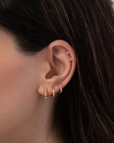 a woman wearing gold ear cuffs with small diamonds