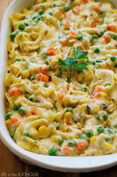 a casserole dish with peas, carrots and macaroni in it