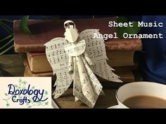 sheet music angel ornament sitting next to a cup of coffee and an old book