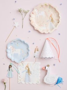 some paper plates and decorations on a pink background